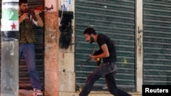 A Free Syrian Army fighter runs for cover during clashes with Syrian Army soldiers in Aleppo's Salaheddine district on August 5.