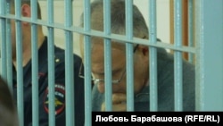 А.Хорошавин читает книгу во время чтения приговора