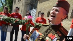 A World War II veteran wearing a Soviet officer uniform sings during a march in the center of Kyiv to celebrate Victory Day on May 9 2013. 