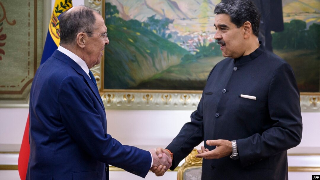 Venezuela's President Nicolas Maduro (right) shakes hands with Russian Foreign Minister Sergei Lavrov in Caracas on February 20.