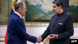 Venezuela's President Nicolas Maduro (right) shakes hands with Russian Foreign Minister Sergei Lavrov in Caracas on February 20.