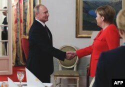 Russin President Vladimir Putin (left) and German Chancellor Angela Merkel shake hands during a bilateral meeting on the sidelines of the G20 in Buenos Aires.