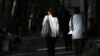 Iranian women walk on a Tehran street without wearing the mandatory head scarves.