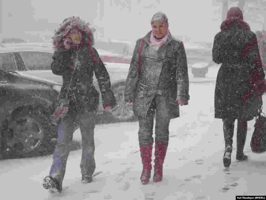 Russia -- People walk in snow storm in Moscow, 25Mar2011