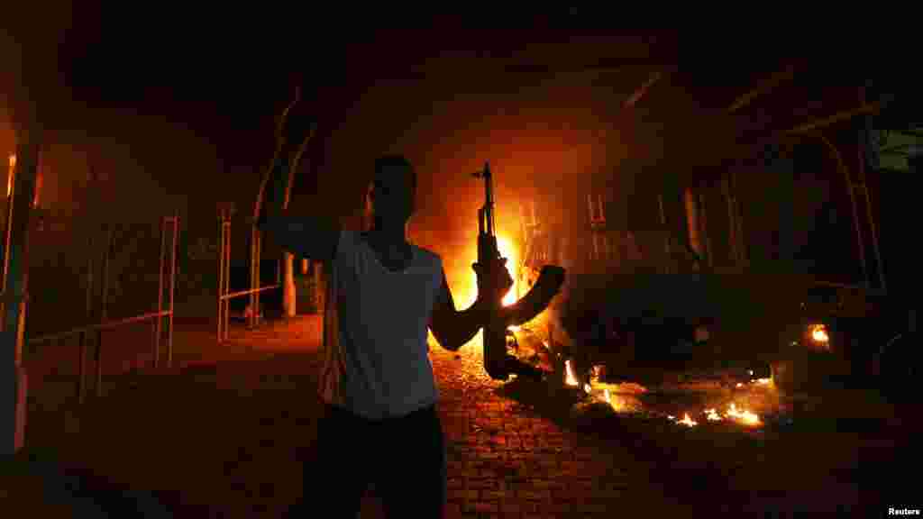 An armed man reacts as the U.S. Consulate in Benghazi, Libya, is seen in flames in an incident that killed U.S. Ambassador Chris Stevens and three other Americans. (Reuters/Esam al-Fetori)