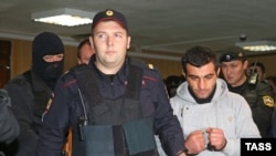 Orkhan Zeynalov (right) is escorted to a courtroom in Moscow on October 17.