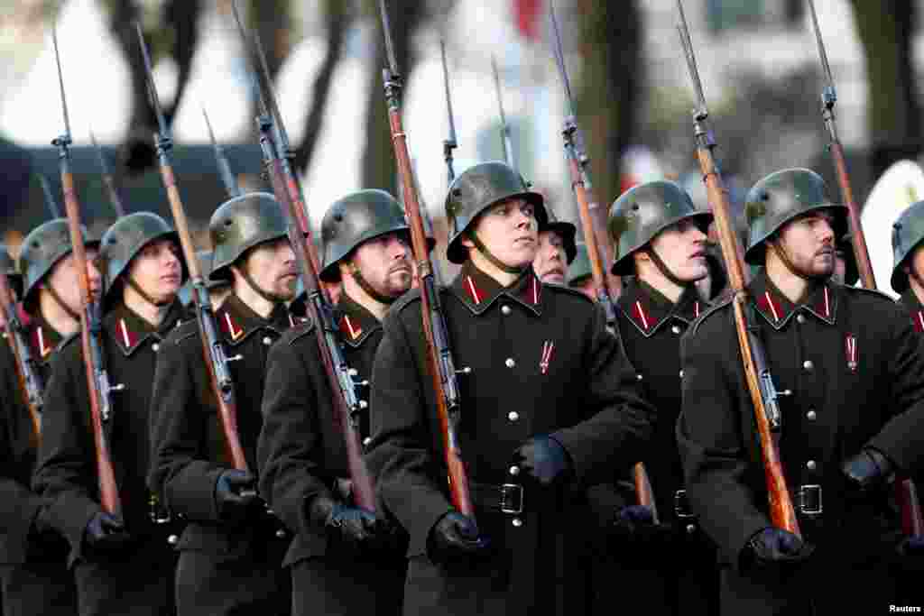 Латвійські воїни, одягнені в історичні мундири, з мушкетами на плечах
