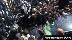 PPP supporters gather around the car of former President Asif Ali Zardari on his arrival in the National Accountability Bureau in Islamabad on March 20.