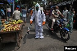 Муніципальний працівник дезинфікує вулицю в Колькаті, Індія, вересень 2020 року