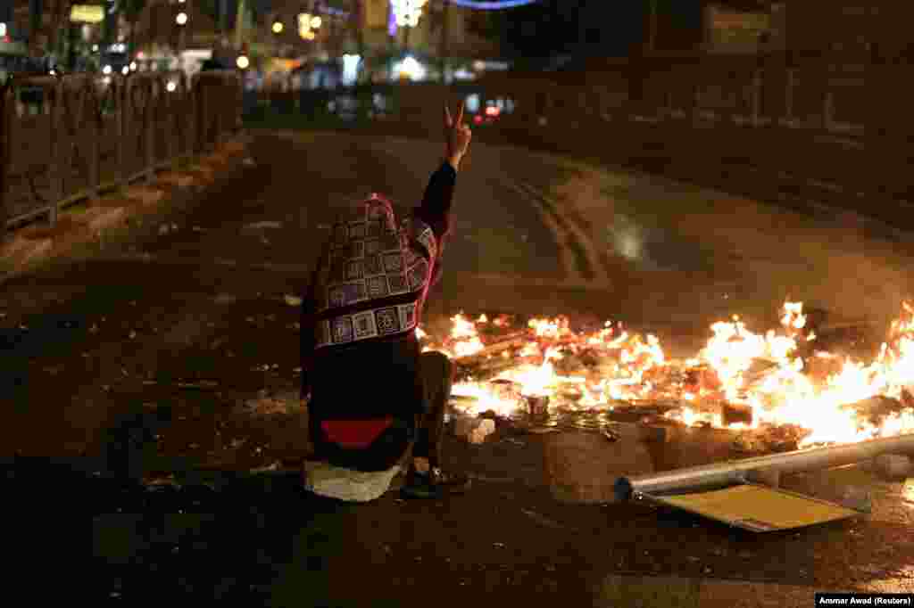 Folytatódik a ramadam, és folytatódnak az összetűzések a palesztinok és az izraeli rendőrség között. A képen egy palesztin ül a felgyújtott barikád mellett Jeruzsálemben április 22-én.