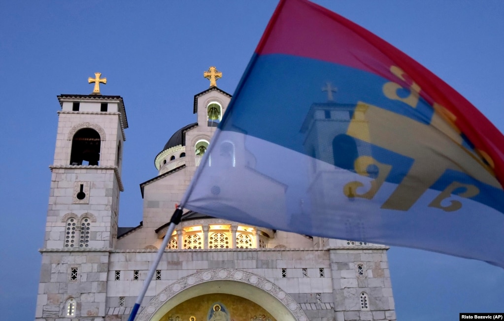 Mali i Zi -- Një mbështetës i opozitës duke valëvitur një flamur të vjetër serb gjatë protestës së udhëhequr nga kisha përpara Kishës Ortodokse Serbe në Podgoricë, 27 gusht 2020.