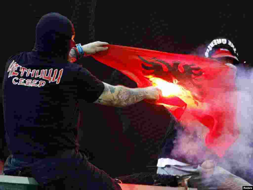 A supporter of Serbia's soccer team burns an Albanian flag before the Euro 2012 qualifying soccer match between Italy and Serbia in Genoa on October 12. The match was suspended after just six minutes and was likely to be abandoned when away fans threw flares onto the pitch and at Italian fans. Photo by Alessandro Garofalo for Reuters