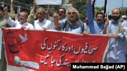 Pakistani journalists denounce censorship, holding a banner that reads: "stop sacking journalists," in the northwestern city of Peshawar on July 16