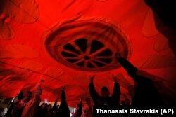 Supporters of a movement for voters to boycott the referendum hold a huge Macedonian flag as they celebrate in central Skopje after election officials gave low turnout figures.