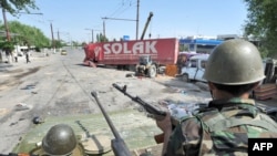 Kyrgyzstan -- Ethnic Uzbeks and Kyrgyz jointly dismantle a street barricade on the border of Uzbek district in the southern city of Osh, 20Jun2010