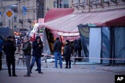 Anchetatori și ofițeri de poliție ruși la locul exploziei din Sankt Petersburg, Rusia, 2 aprilie 2023.