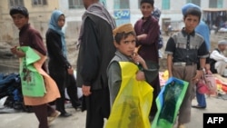 Afghan children sell plastic bags at a market in Kabul