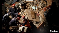 Спасатели Непала, Турции и Китая ведут поисково-спасательные работы на месте обрушившегося отеля в Катманду, 27 апреля 2015 года.