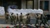 Ukraine -- Armed men, who are wearing black and orange ribbons of St. George - a symbol widely associated with pro-Russian protests in Ukraine, pass by barricades outside the mayor's office in Slovyansk, April 18, 2014