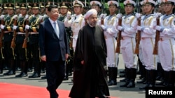 Iranian President Hassan Rohani (right) and Chinese President Xi Jinping review an honor guard during the welcome ceremony at the Xijiao State Guesthouse in Shanghai in May 2014.