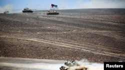 Tanks advance during the Eager Lion military exercise at the Jordan-Saudi Arabia border, south of Amman, May 17, 2017