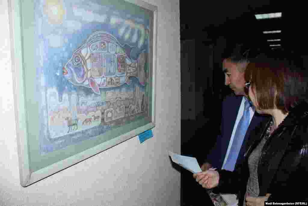 Посетители выставки знакомятся с картиной художника С. Альжанова &quot;Великое наследие Казахстана&quot;. Астана, 17 сентября 2015 года.