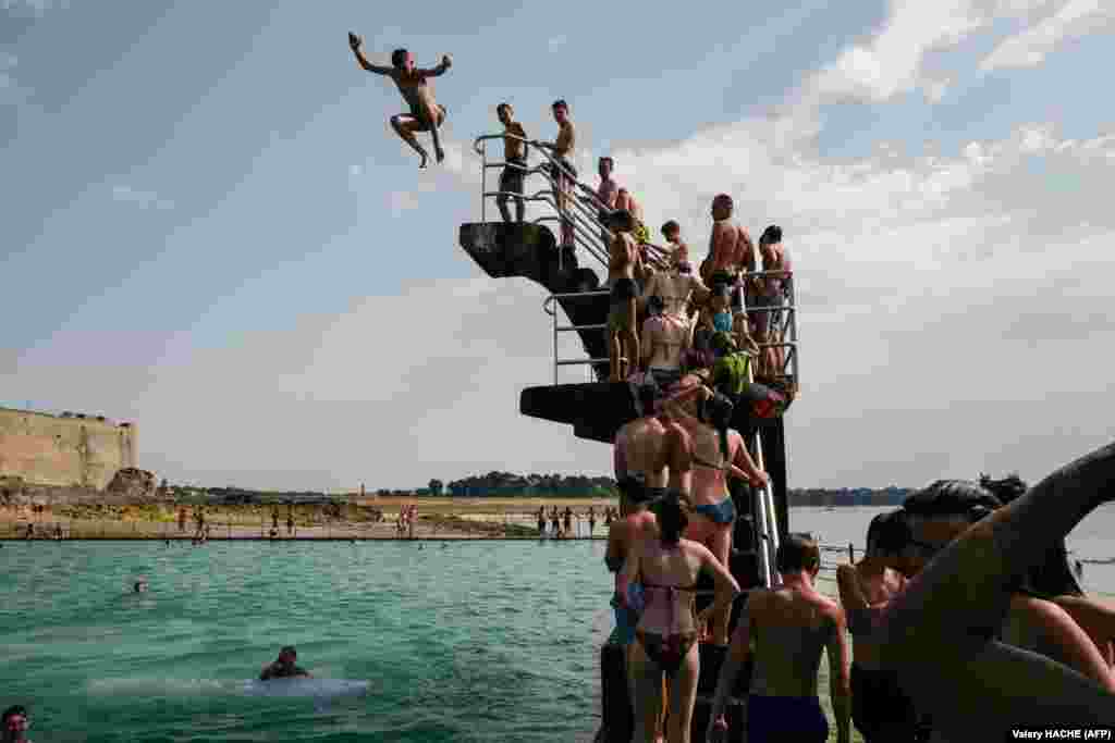 People queue to dive into the sea in Brittany, France, as a new heatwave in northern Europe set records in several countries. (AFP/Valery Hache)