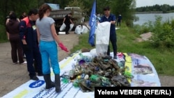 Активисты, откликнувшиеся на призыв акции по очистке малого озера в центральном парке Караганды, складируют собранный из озера и с прилегающей к нему территории мусор. Караганда, 30 июля 2016 года. 