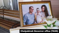 A photo of Igor, Milana, and Anastasia Kramarenko, who died in the collapse, is displayed before a farewell ceremony in Magnitogorsk on January 4.