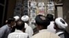 Iran -- Clergymen follow the political news as they read daily newspapers outside a news stand in the religious Shi'ite Muslim city of Qom, 09Jun2013