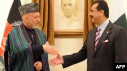 Pakistani Prime Minister Yusuf Raza Gilani (right) greets Afghan President Hamid Karzai at the Prime Minister's House in Islamabad.