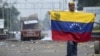 A demonstrator holds a Venezuelan flag on the Francisco de Paula Santander international bridge in Urena, Venezuela, border with Colombia on February 24, 2019. 