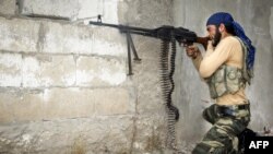 A rebel fighter fires his machine gun at Syrian government troops at the citadel in the town of Harem on October 31.