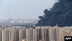 A thick plume of smoke rises above an oil refinery west of the flashpoint city of Homs in early December.
