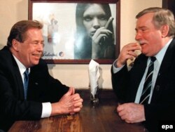 Președintele Cehiei, Vaclav Havel (stânga) și fostul președinte al Poloniei, Lech Walesa, făcând glume despre cum s-au lăsat de fumat, într-un pub la Varșovia, 10 martie 1998