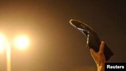 Egypt -- A protester waves a shoe, a sign of disrespect, in Tahrir Square to Egyptian President Hosni Mubarak's televised speech in Cairo, 01Feb2011