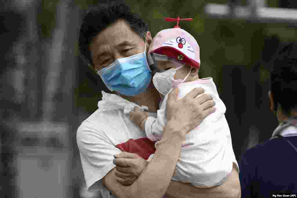 Чоловік і дитина &ndash; в захисних масках. Пекін, Китай