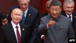 На передньому плані очільник Росії Володимир Путін розмовляє із керманичем Китаю Сі Цзіньпіном, а також інші запрошені лідери країн на урочистості з нагоди 80-ї річниці перемоги над Японією та закінчення Другої світової війни. Пекін, Китай. 3 вересня 2025 року