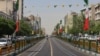Vehicles and motorbikes drive along a street adorned with flags of Iran at the Revolution Square in Tehran on April 28, 2026.