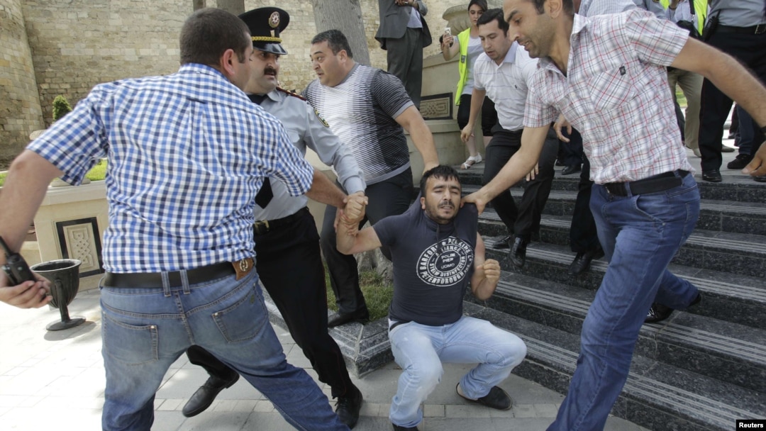 Azerbaijani plainclothes police officers detain an opposition supporter during an antigovernment protest in central Baku on May 21.