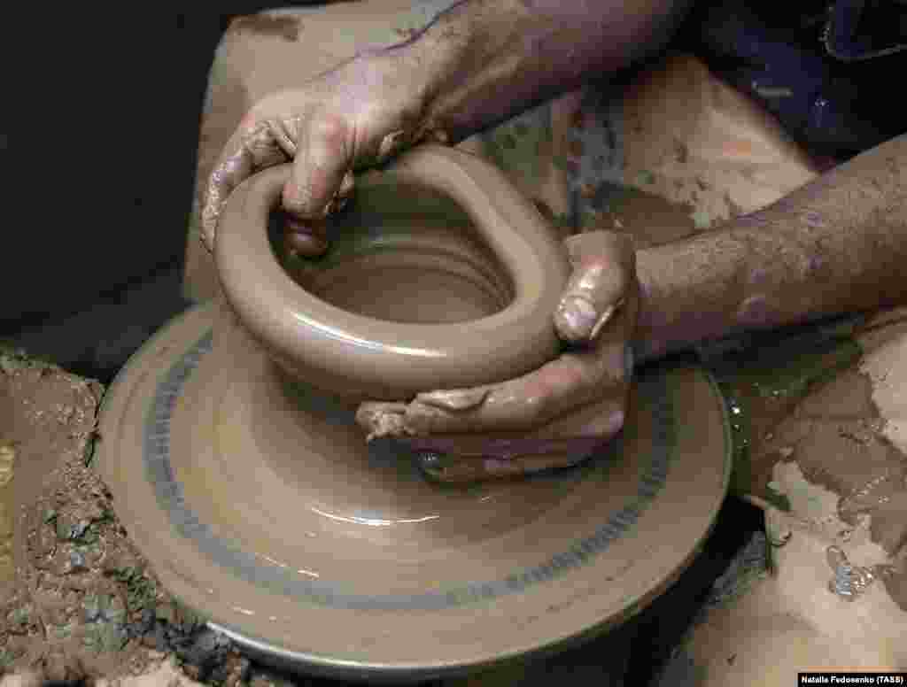 A vessel is shaped on a potter&rsquo;s wheel inside the factory.