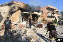 Rescuers inspect rubble at the site of an Israeli strike on a pharmacy in the southern Lebanese village of Akbiyeh on September 24.