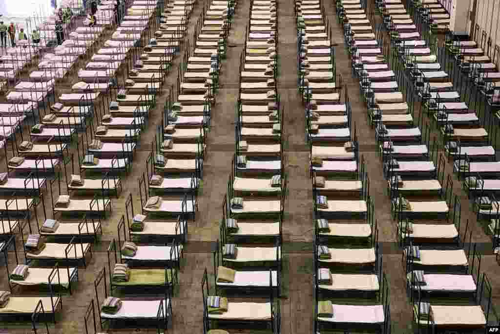 Workers set up beds at an exhibition center that has been converted into a hospital in Wuhan in China&#39;s central Hubei Province, which is the epicenter of the coronavirus outbreak. (AFP)