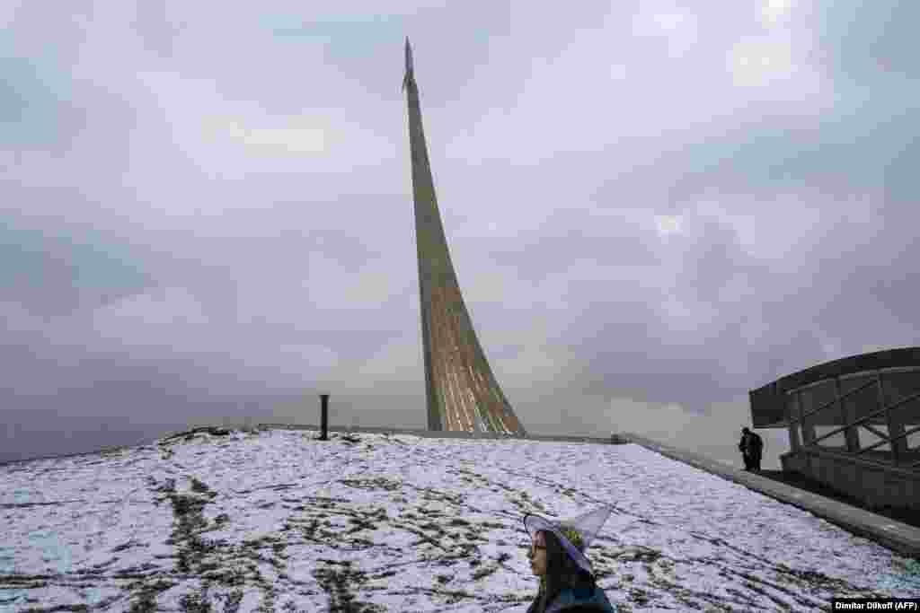 A girl wearing a witch&#39;s hat walks in front of the Soviet-era Monument To The Conquerors Of Space on Halloween in Moscow. (AFP/Dimitar Dilkoff)