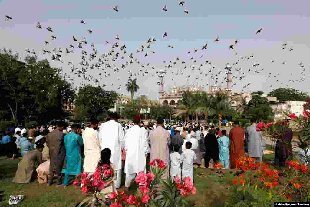 На фона на ръста на случаите на коронавирус пакистански мюсюлмани се събират, за да отпразнуват Рамазан Байрам в Карачи.