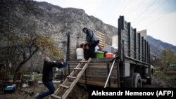 Armenians pack their belongings as they leave their house in the town of Kalbajar, November 12, 2020