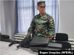 Ofițer demonstrând, într-o unitate militară moldoveană, o pușcă de bruiere a dronelor