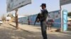 FILE: A police officer stands guard in front of a voting center in the northern province of Kunduz.