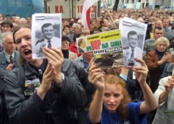 Young people holding portraits of opposition presidential candidate Uladzimer Hancharyk during a rally of his supporters in Minsk on September 2, 2001.