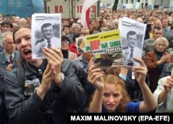 Young people holding portraits of opposition presidential candidate Uladzimer Hancharyk during a rally of his supporters in Minsk on September 2, 2001.